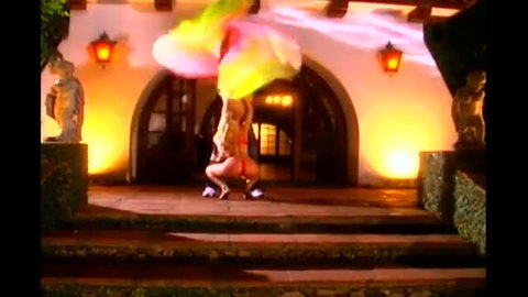 Blonde dancer in red lingerie shaking colorful scarf outdoors at night
