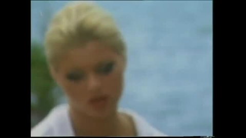 Blonde woman in white top with smoky eye makeup, ocean background