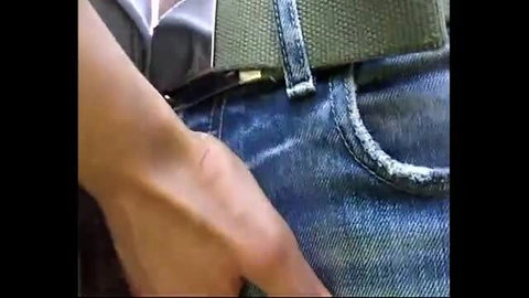 Man in jeans unbuttons pants, close-up of hand grabbing bulge