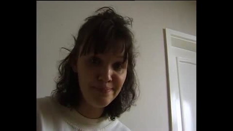 Brunette woman in white top looking at camera