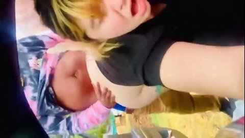 Woman in black top holding Asian baby outdoors