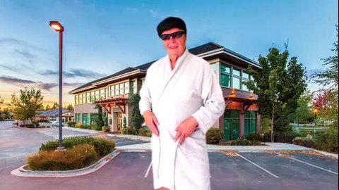 Man in white bathrobe outdoors at dusk in parking lot