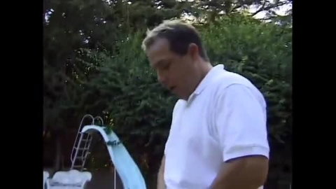 Man in white polo shirt by backyard pool