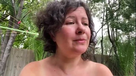 Curly haired woman with sunburn and mozzie bites outdoors topless