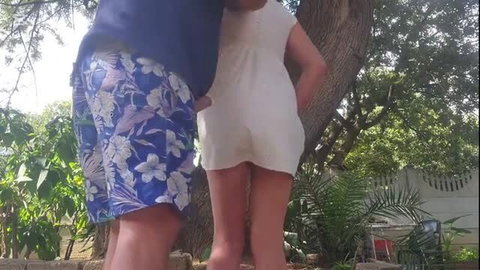 Couple outdoors, guy in floral shorts cumming near girl's white dress