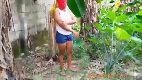 Masked amateur in backyard wearing red mask and booty shorts