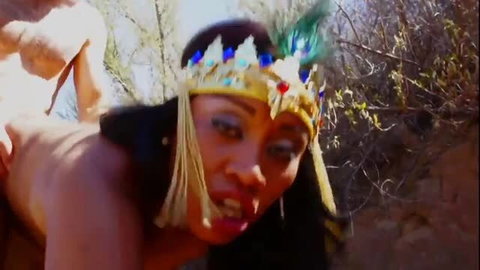 Middle Eastern woman with golden crown performing oral outdoors
