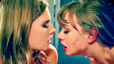 Blonde and brunette hotties noses touching lips pursed in intense lesbian kiss tease