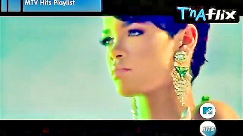 Close-up portrait of sexy ebony Rihanna with blue hair, bold makeup and dangling earrings in MTV Hits Playlist on TnAflix
