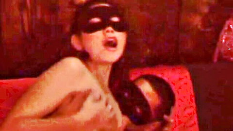 Topless masked Asian woman in erotic softcore pose, seductive expression