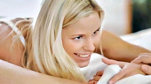 Dido Angel in white lingerie smiling seductively on bed