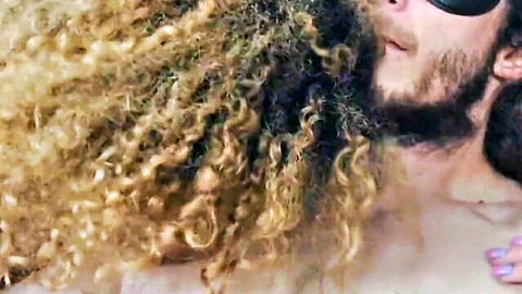 Curly-haired bearded man in sunglasses during intimate teen tease encounter