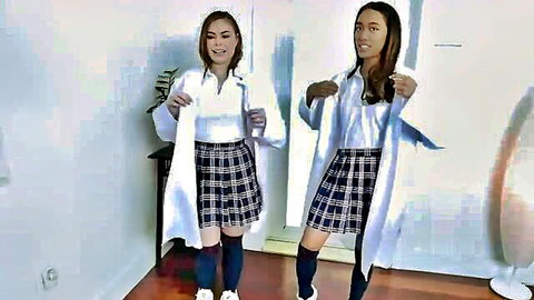 Two Asian schoolgirls in uniforms and lab coats posing playfully after class