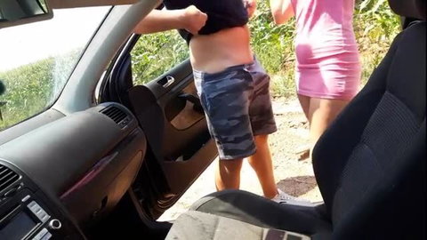Man lifts shirt outdoors showing belly next to woman in tight pink dress