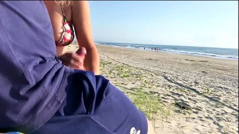 Woman in floral bikini gives handjob on sunny beach