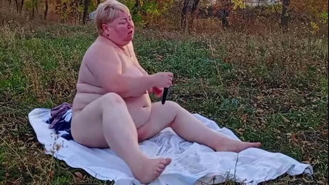 Chubby mature woman masturbating outdoors with black vibrator