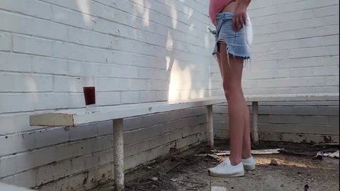 Woman in denim skirt exposing ass outdoors at abandoned sports club