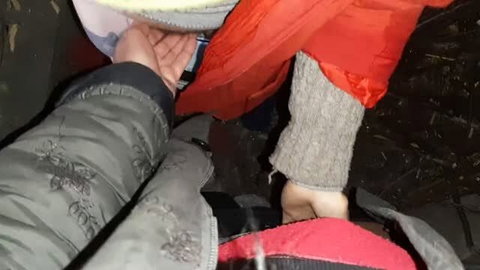 Women in winter coats touching in secluded outdoor spot