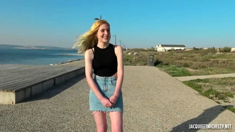 Annie Charlotte, smiling 19yo French teen in black tank top and denim skirt outdoors by sea