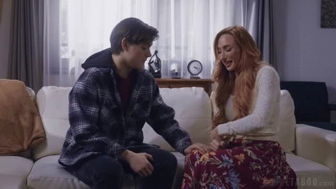 Sophia Locke in floral skirt on couch with young man, intimate scene