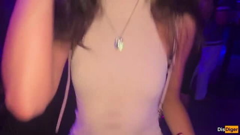Brunette in tight white tank top and pendant necklace at nightclub