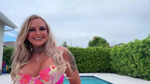 Blonde with big tits in pink floral bikini by pool