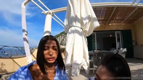 Daniela Antury in blue shirt on sunny balcony, OnlyFans adult video