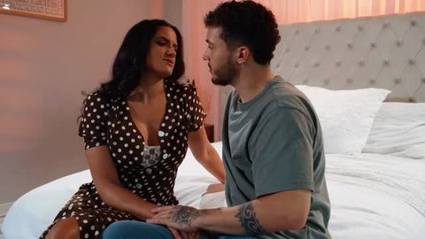Natasha Nice in polka dot dress with Diego Perez on bed