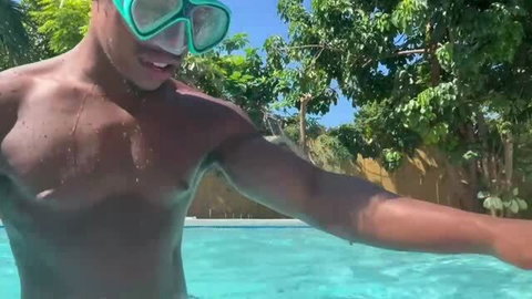 Shirtless Black man in pool wearing swim goggles