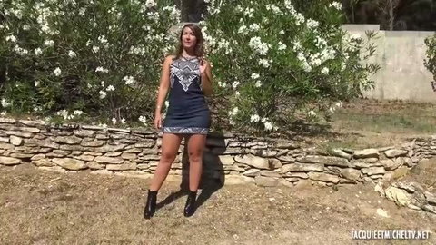 Lexi Doll posing outdoors in short black dress and boots