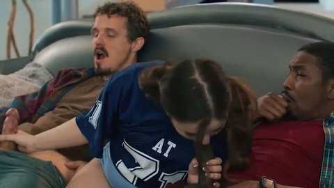 Brunette cheerleader giving oral to two men in football locker room scene