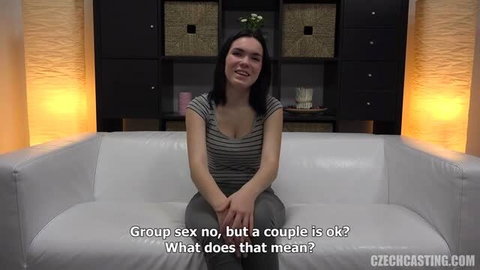 Petra from Czech Casting on white couch, smiling in striped top