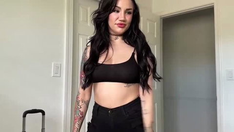 Tattooed brunette showing underboob in black crop top