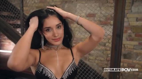 Carolina Guerrero in black fringe lingerie with silver jewelry, hands in hair, seductive gaze