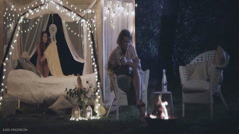 Katy Sky seductive in sheer dress by candlelit outdoor canopy bed at night