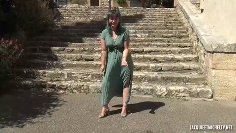Khala in green dress posing on stone steps, submissive pose