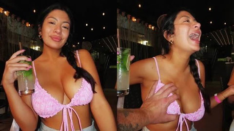 Busty brunette in pink bikini top holding cocktail at bar