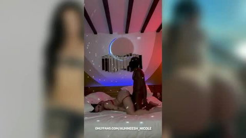 Woman riding BBC on bed in red and blue lit bedroom