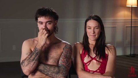 Katrina Colt in red lingerie sitting shirtless with tattooed man in EdgedAndBound scene