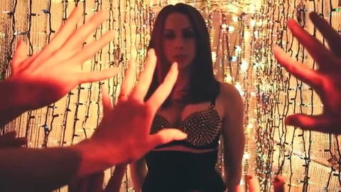 Chanel Preston in black studded lingerie reaching toward hands