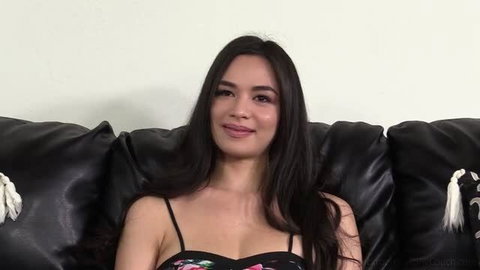 Scarlett Alexis 22y seated on black couch in floral top