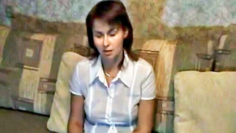 Asian woman in sheer white blouse teasing on couch