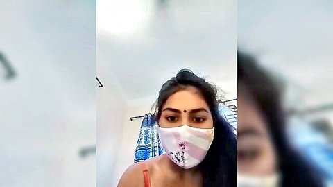 Seductive Indian woman in pink floral mask with smoky eyes teasing solo