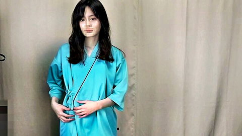 Beautiful Asian woman in light blue medical robe, candid health checkup shot