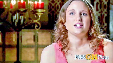 Curly-haired woman smiling in pink tank top at swinger softcore party