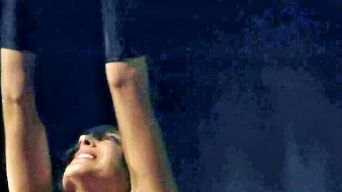 Bound subsgirl arms raised smiling in BDSM fantasy