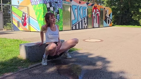 Pixie squatting in white tank top and black shorts outdoors