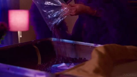 Angel Youngs in purple fur coat pouring glitter in adult scene