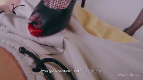 Molly Devon in fishnet stockings and black heels giving a footjob