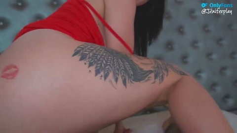 Jenifer Play shows her tattooed thigh and ass, red lingerie, seductive pose